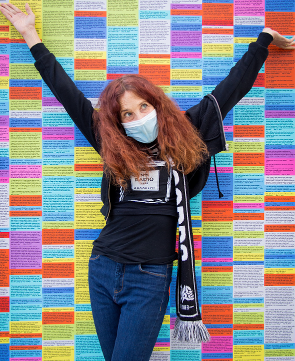 Lisa Levy in front of Wall of Lies art exhibit